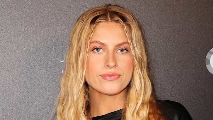 Xandra Pohl poses in a black silk dress and sports her blonde hair in a soft wave.